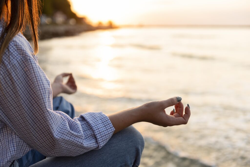 mujer-meditando-en-la-playa-con-espacio-de-copia